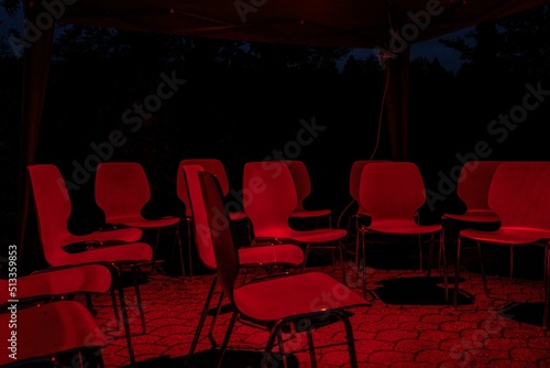 Empty chairs under a red light outdoors photo