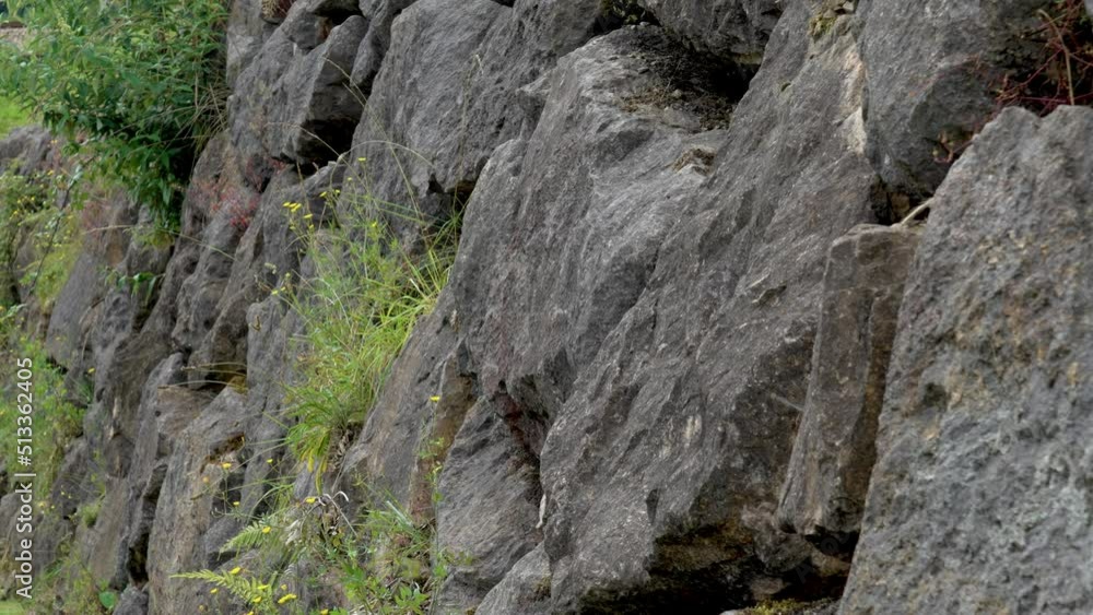 Natural retaining wall made of large, durable boulders. Stacked stones at the base of the building. Close-up Natural retaining wall made of large, durable boulders. Stacked stones at the base of the building. Close-up