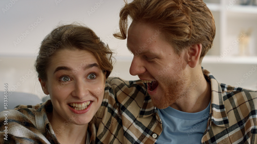 Happy couple watching tv at home closeup. Impressed family enjoy streaming film Happy couple watching tv at home closeup. Impressed family enjoy streaming film