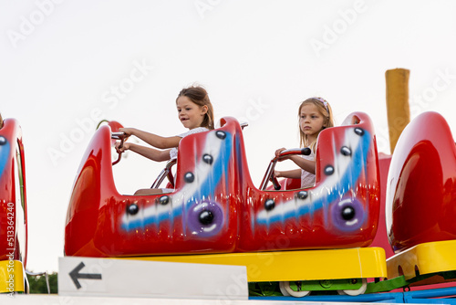 two happy sisters little girls having fun at the amusement park