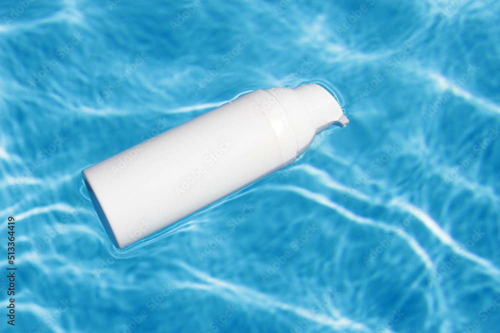 White cosmetic tubes on the water surface. Blank label for branding mock-up. Summer vacation cosmetics concept. Flat lay. Copy space. White cosmetic tubes on the water surface. Blank label for branding mock-up. Summer vacation cosmetics concept. Flat lay. Copy space.