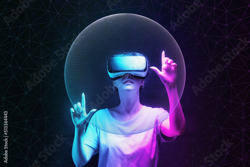 Metaverse and 3D simulation. Portrait of young woman in VR glasses creates mesh sphere. Dark background with neon abstracts. The concept of virtual reality and futurism photo