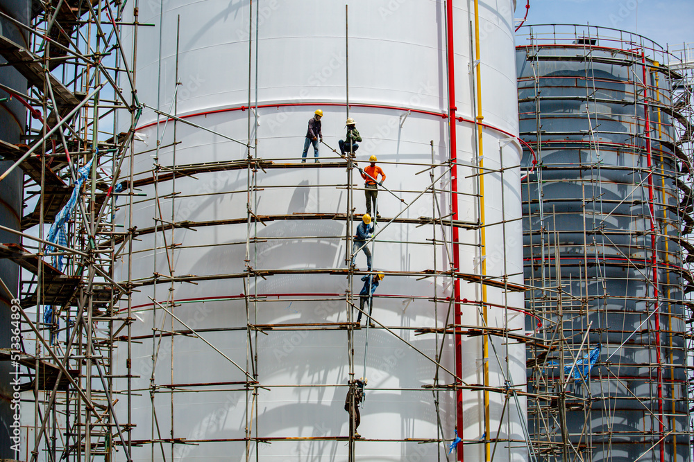 Fototapeta premium Worker male assembly in progress storage new tank oil inspection scaffolding