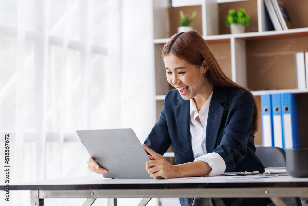 Happy excited young Asian woman with a laptop at home sitting in-home office, Emotional girl feeling glad and happy Happy excited young Asian woman with a laptop at home sitting in-home office, Emotional girl feeling glad and happy