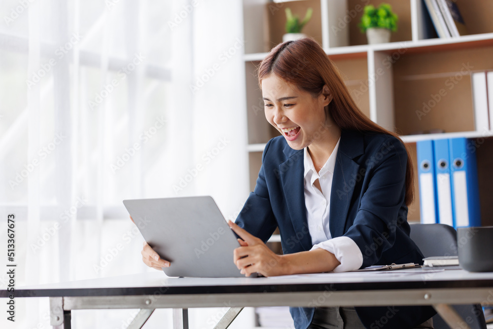 Happy excited young Asian woman with a laptop at home sitting in-home office, Emotional girl feeling glad and happy Happy excited young Asian woman with a laptop at home sitting in-home office, Emotional girl feeling glad and happy