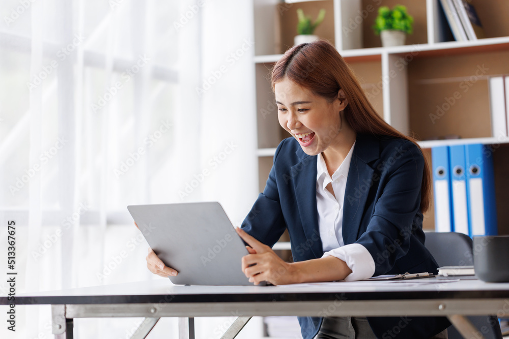 Happy excited young Asian woman with a laptop at home sitting in-home office, Emotional girl feeling glad and happy Happy excited young Asian woman with a laptop at home sitting in-home office, Emotional girl feeling glad and happy