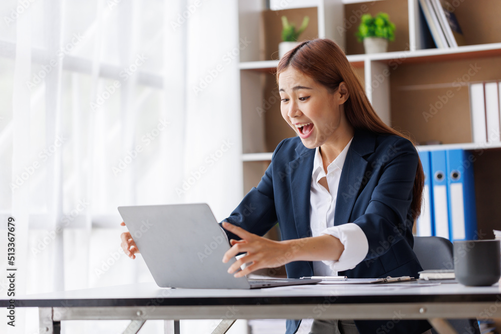 Happy excited young Asian woman with a laptop at home sitting in-home office, Emotional girl feeling glad and happy Happy excited young Asian woman with a laptop at home sitting in-home office, Emotional girl feeling glad and happy