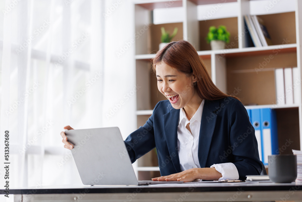 Happy excited young Asian woman with a laptop at home sitting in-home office, Emotional girl feeling glad and happy 