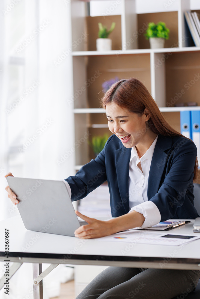 Happy excited young Asian woman with a laptop at home sitting in-home office, Emotional girl feeling glad and happy Happy excited young Asian woman with a laptop at home sitting in-home office, Emotional girl feeling glad and happy