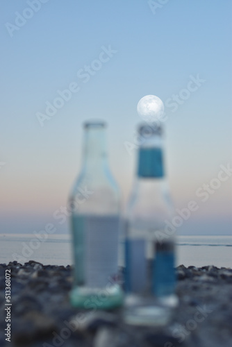 in summer, even the bottles left after the party observe the sea and the full moon