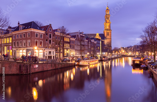 Beautiful old houses on the city waterfront of Amsterdam at sunset.