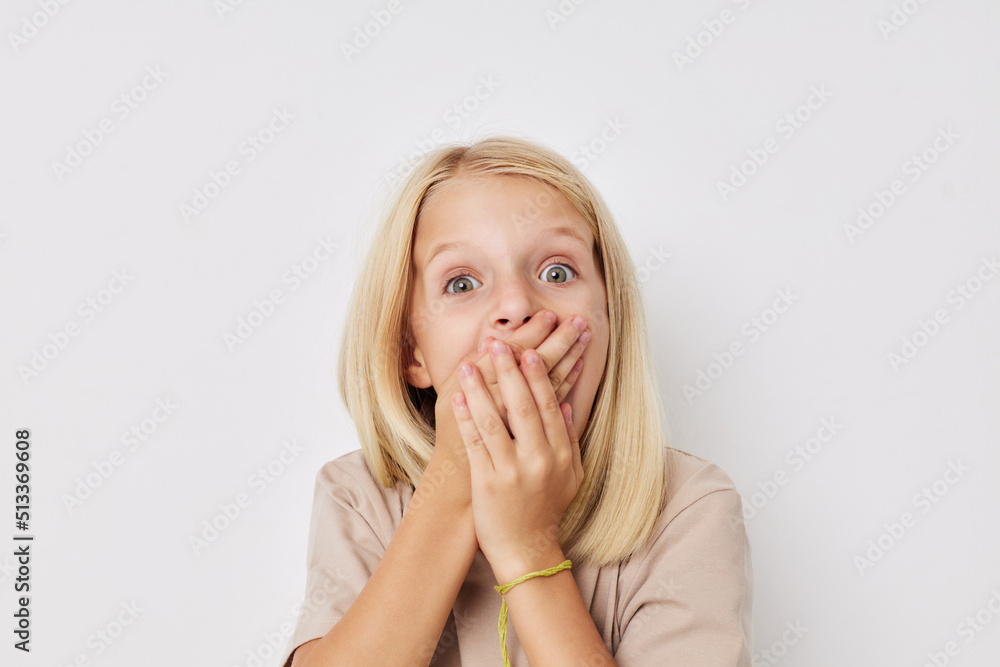 Portrait of a smiling little cutie beige t-shirts grimace on a light background Portrait of a smiling little cutie beige t-shirts grimace on a light background
