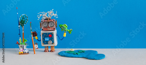 Fisherman robot caught big fish. Angler accessories rod bucket bait. Fishing and vacation Robotic concept.blue lake with water lily and fishes. Blue gray background, copy space photo