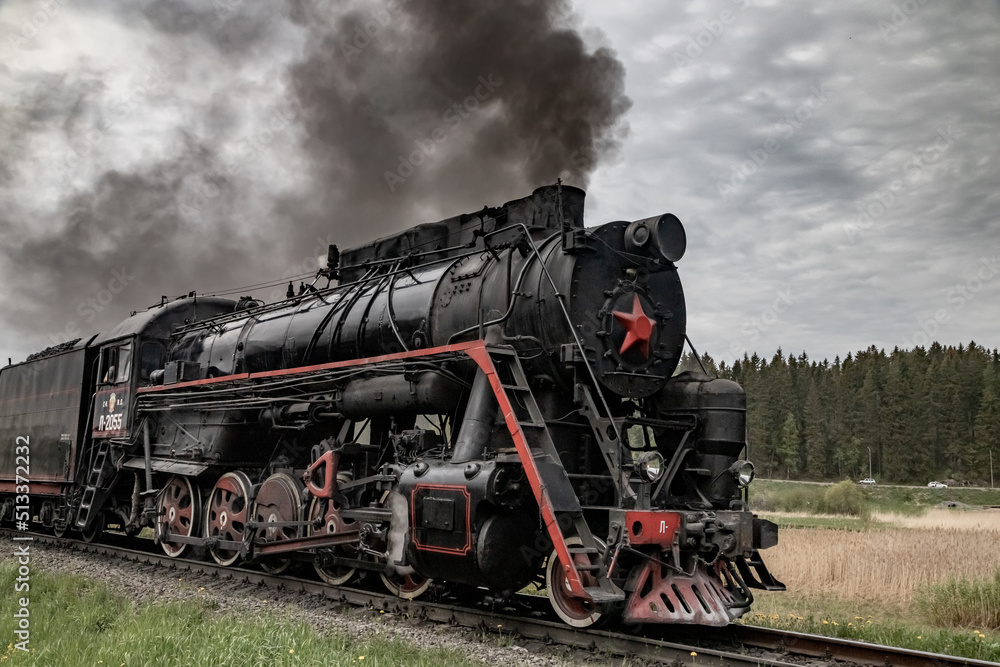Obraz premium An old steam locomotive Ruskeala Express arriving at Sortavala station. Historical train in Karelia.