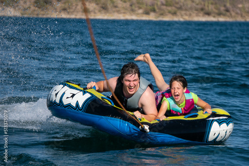 Father and daughter tubing on the water