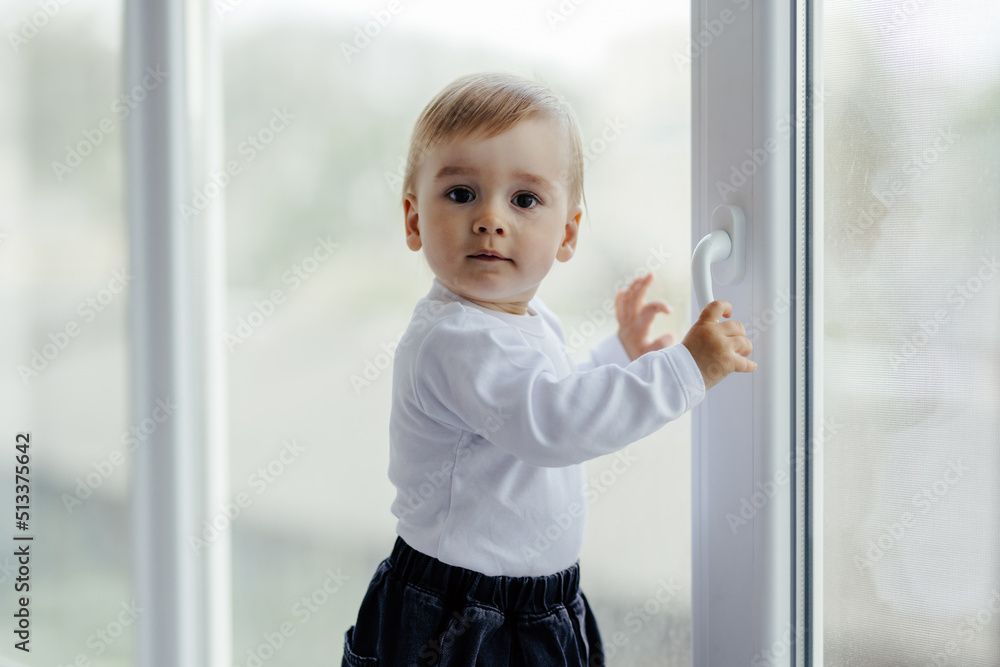 Little, lost in thoughts, and little boy sitting by the window and thinking and waiting for something. Little, lost in thoughts, and little boy sitting by the window and thinking and waiting for something.