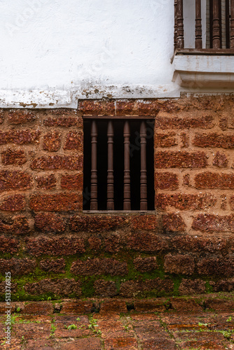 Interiors of a fort in Goa which shows the building architecture of Portuguese colonial influence having laterite stones, windows, doors and tiled roofs with the Monsoon sky in background photo