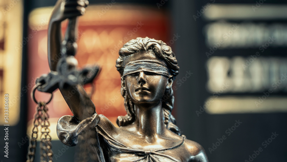 Legal and law concept statue of Lady Justice on books background Legal and law concept statue of Lady Justice on books background