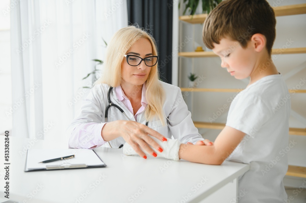 Obraz premium female doctor and young boy with a broken arm.