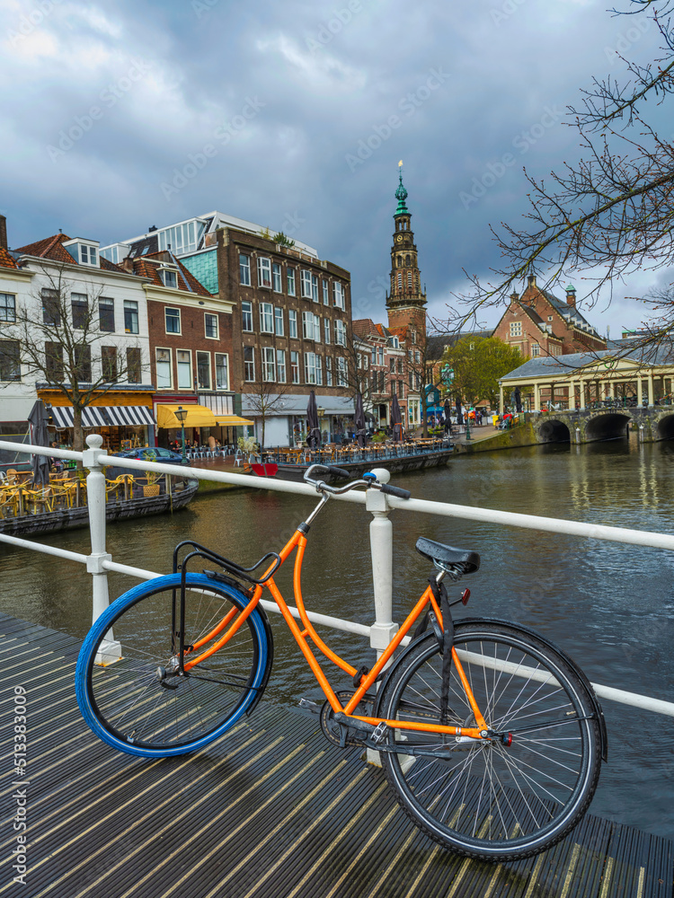 Bicycle on a wooden bridge with beautiful dutch houses on a canal in the in Leiden, Netherlands