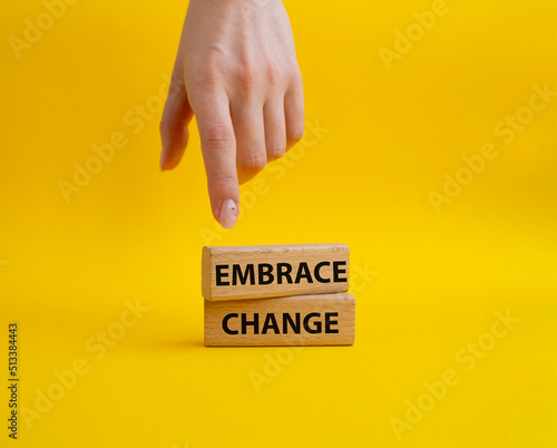 Embrace change symbol. Concept word Embrace change on wooden blocks. Beautiful yellow background. Businessman hand. Business and Embrace change concept. Copy space