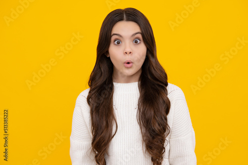 Surprised teenager girl. Teenager child girl with shocked facial expression. Surprised face expression, isolated on yellow background. Funny surprise. © Olena
