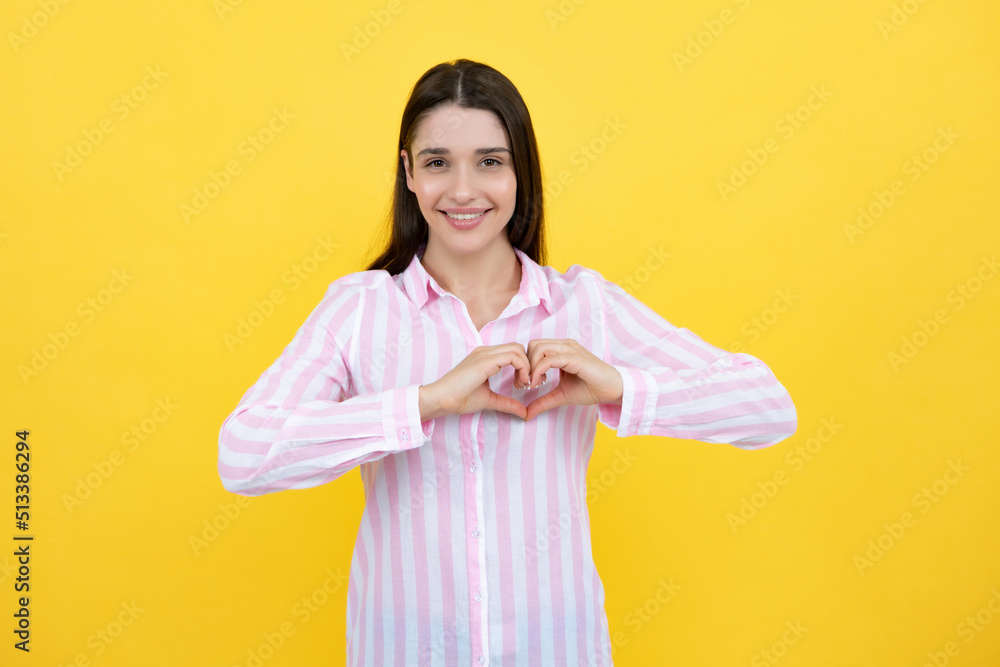 Pretty romantic young woman making a heart gesture, showing love and affection grateful gesture with a happy tender smile. Girl feelings love. Lovely woman with heart sign symbol. Pretty romantic young woman making a heart gesture, showing love and affection grateful gesture with a happy tender smile. Girl feelings love. Lovely woman with heart sign symbol.