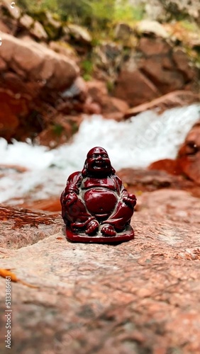 A vertical photo of a buddha in nature