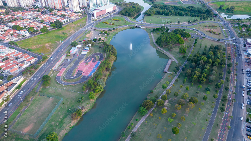 Fototapeta premium Indaiatuba Ecological Park. Beautiful park in the city center, with lake and beautiful trees and houses. Aerial view