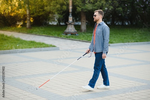 Blind Man Walking On Sidewalk Holding Stick