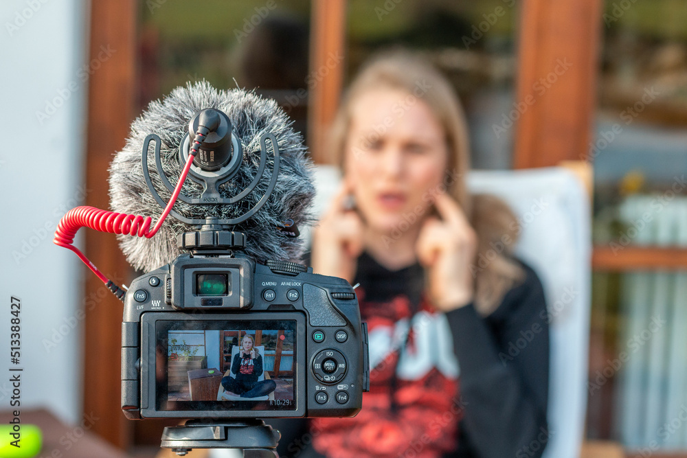 Obraz premium Woman talking in front of the camera in her garden.