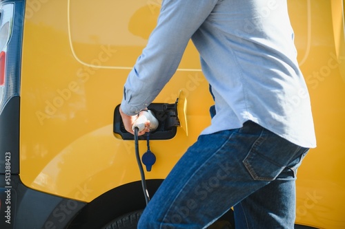 Man charges an electric car at the charging station.