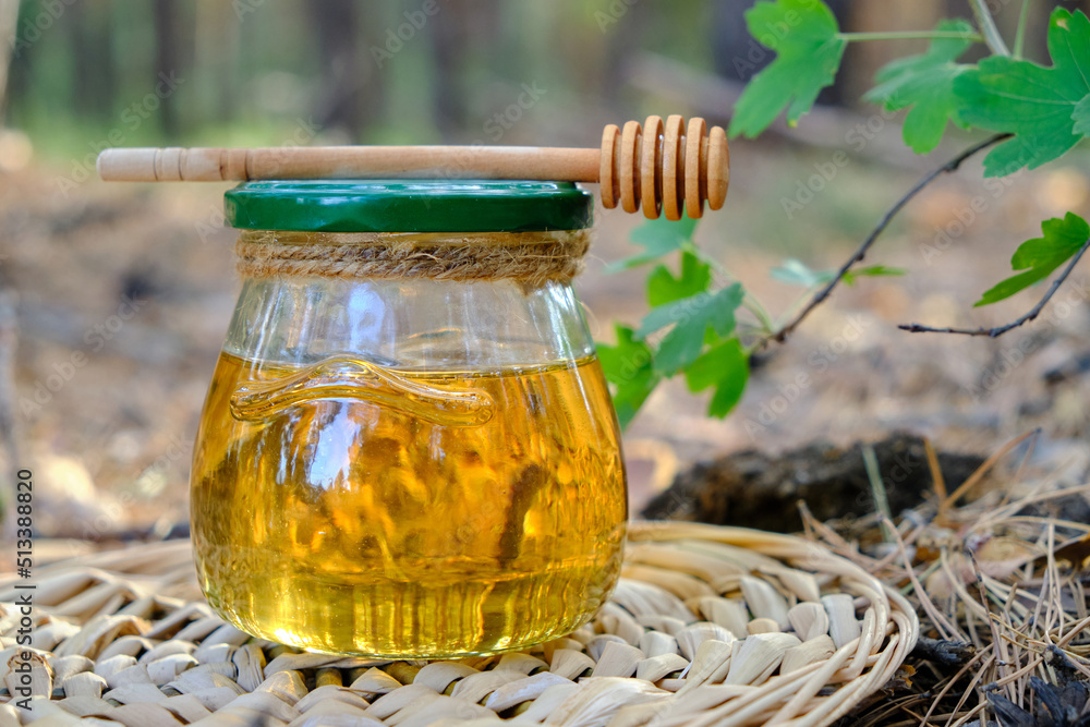 Barrel honey and spoon for honey in summer green grass. Barrel honey and spoon for honey in summer green grass.