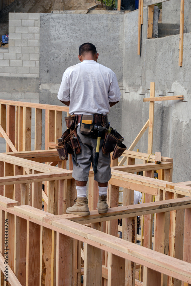 Frame carpenter standing on top of a newly constructed walls Frame carpenter standing on top of a newly constructed walls