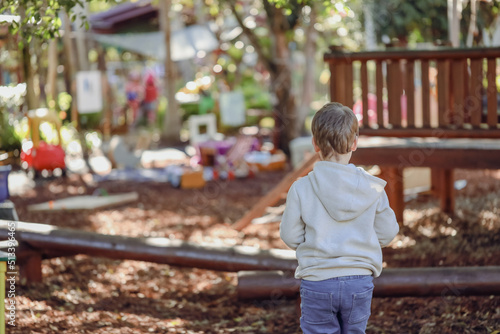 Little preschool boy playing in garden at kindergarten