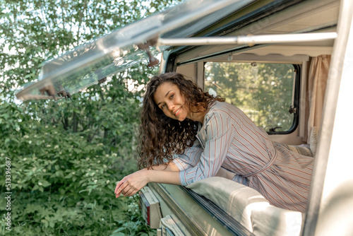 A young woman looks out of the trailer window at summer time