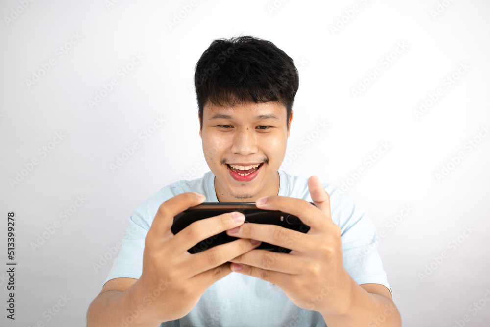 Asian man rejoicing in winning a mobile game on white background Asian man rejoicing in winning a mobile game on white background