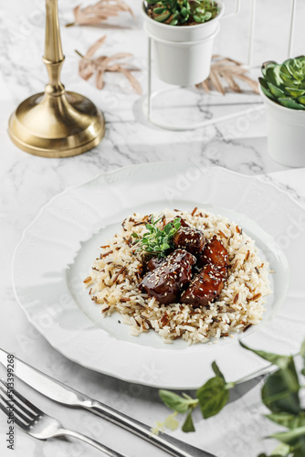 Duck liver fuagra and rice with sauce at the white plate on light marble background. Healthy sea food, hard light, restaurant decor, close up