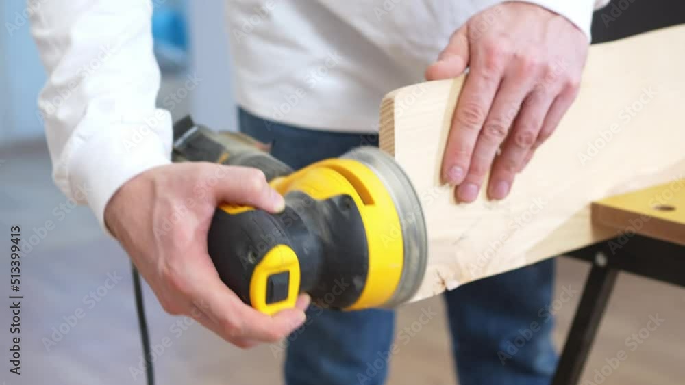 carpenter working on wood grinding machine. grinds and polishes wood. 