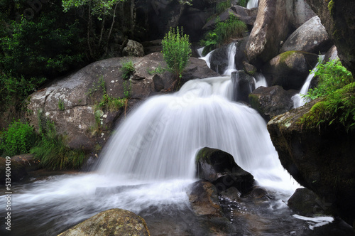 Cascata de um rio com fluxo de água correr por entre as rochas grande velocidade photo