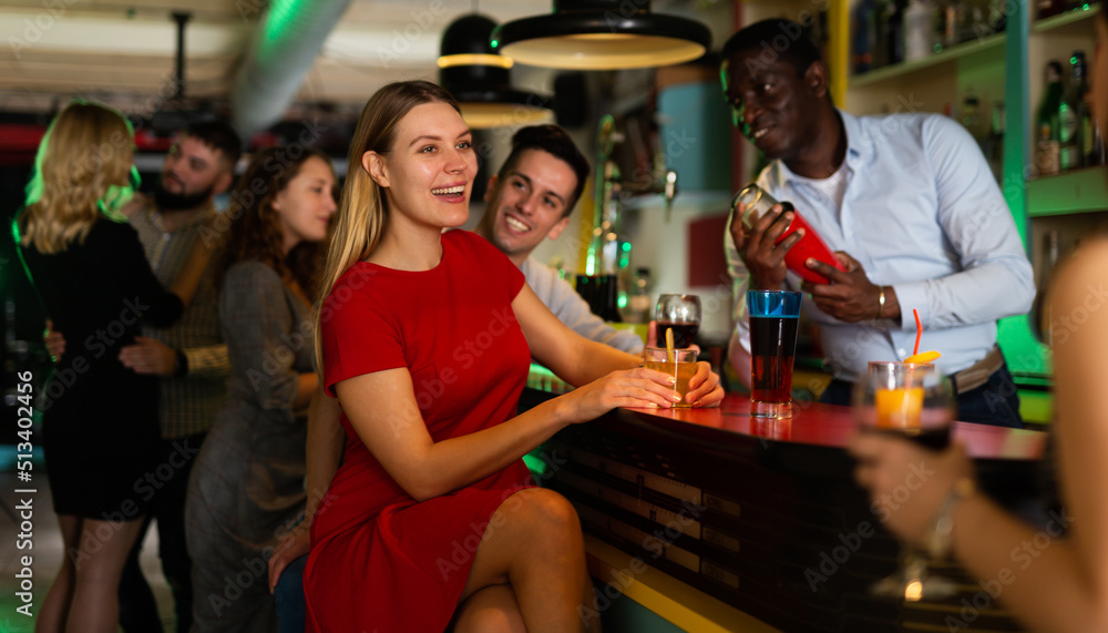 Cheerful girl with best friends partying in bar, dancing and toasting drinks. High quality photo