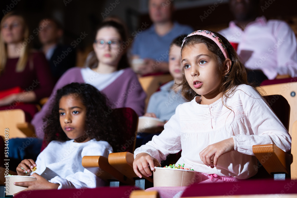 kids sitting at movie in auditorium in cinema