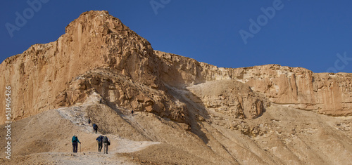 A group of hikers on a footpath to the top of mount Hod Akev, Negev desert, Israel. Popular hiking trail crossing Zin valley near Sde Boker settlement. Sunrise in the Negev desert. Vacation in Israel. photo