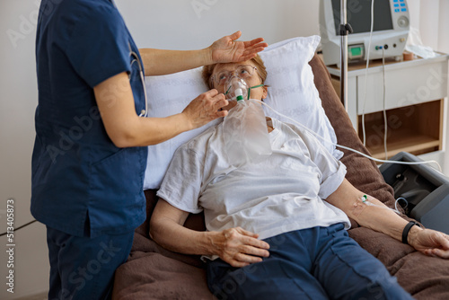 Doctor putting on a breathing mask on a female patient with covid-19. High quality photo