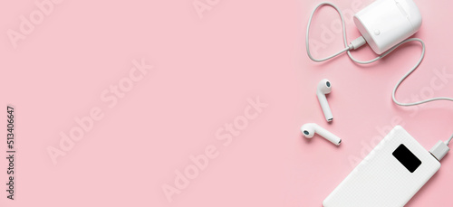 Modern power bank and case for earphones on pink background with space for text