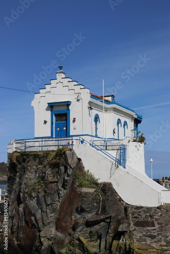 White and blue building of the Nautical Club of Luarca (Asturias, Spain), in the Espigón de la Marchica. Vertical image.