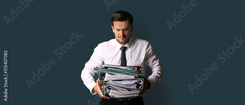 Stressed businessman with many documents on blue background © Pixel-Shot