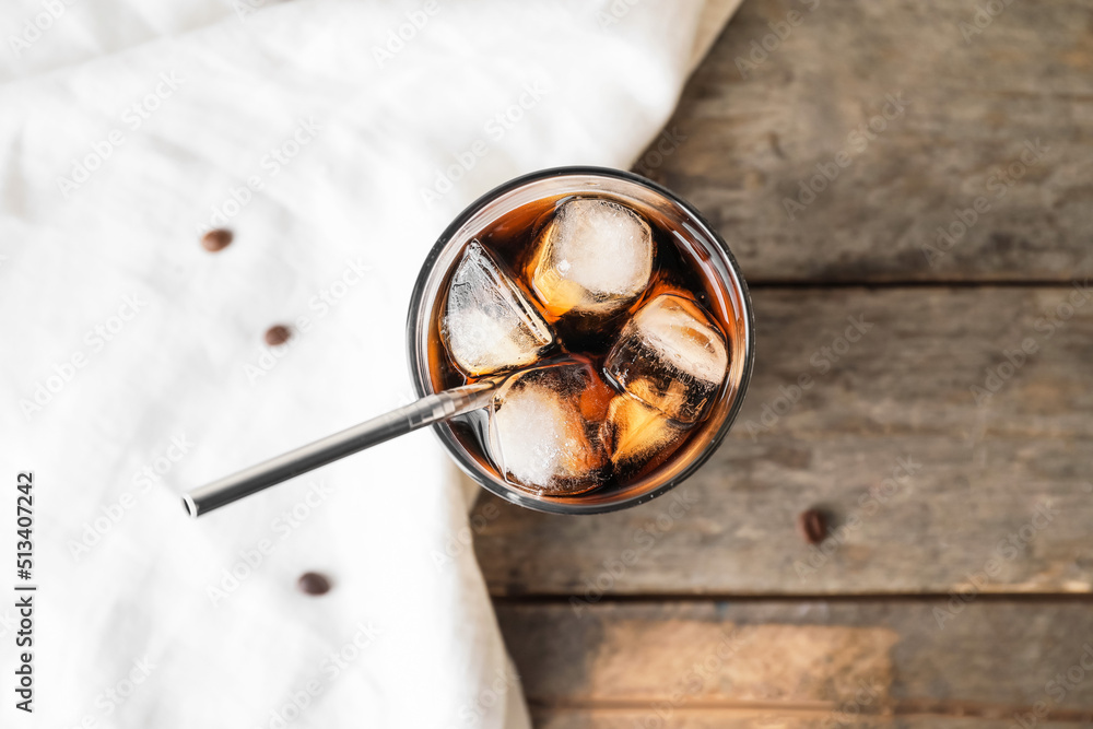 Glass of cold brew with straw on wooden table Glass of cold brew with straw on wooden table