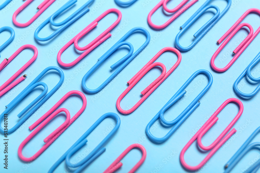 Pink and blue paper clips on color background, closeup Pink and blue paper clips on color background, closeup