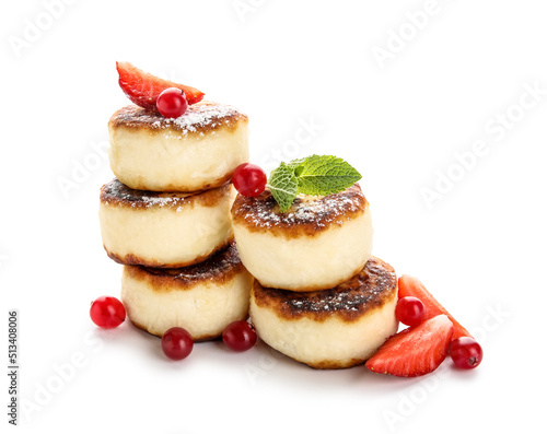 Stack of delicious cottage cheese pancakes with berries and mint leaves on white background